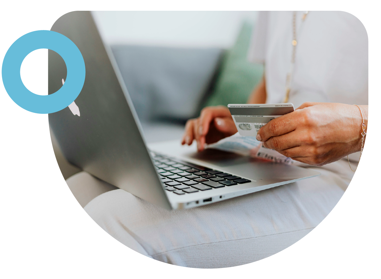 imagen de computador con una persona sosteniendo una tarjeta de crdito frente a el