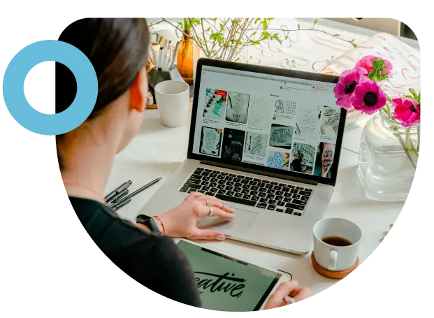 imagen de persona sentada frente a un computador y con un cafe en la mesa